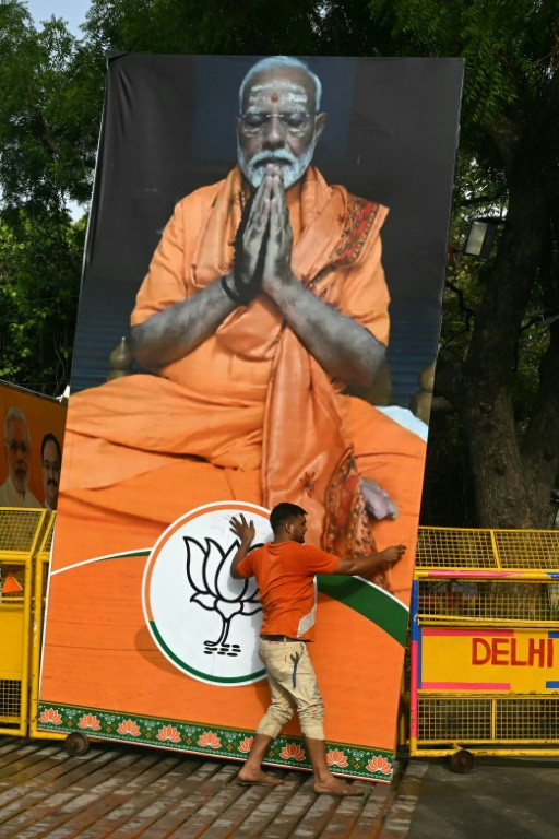 A supporter of India's Prime Minister Narendra Modi carries his portrait on Tuesday as results were announced in the general elections