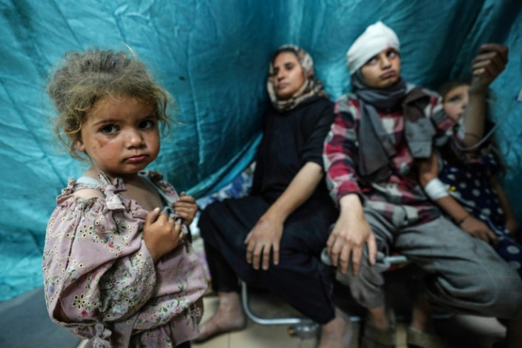 Palestinians, wounded in Israeli strikes on Bureij, arrive for treatment at the Al-Aqsa Martyrs Hospital in Deir al-Balah