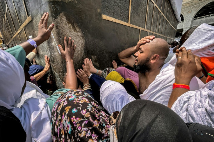 Muslim worshippers touch the Kaaba at the Grand Mosque in Mecca
