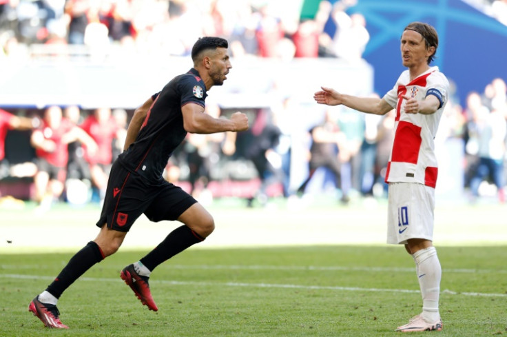 Albania's Klaus Gjasula (L) runs away in celebration after scoring his team's late equaliser in a 2-2 draw with Luka Modric's Croatia