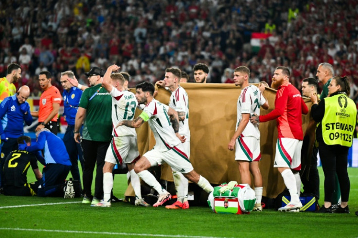 Barnabas Varga (unseen) receives medical treatment after a collision during Hungary's win against Scotland