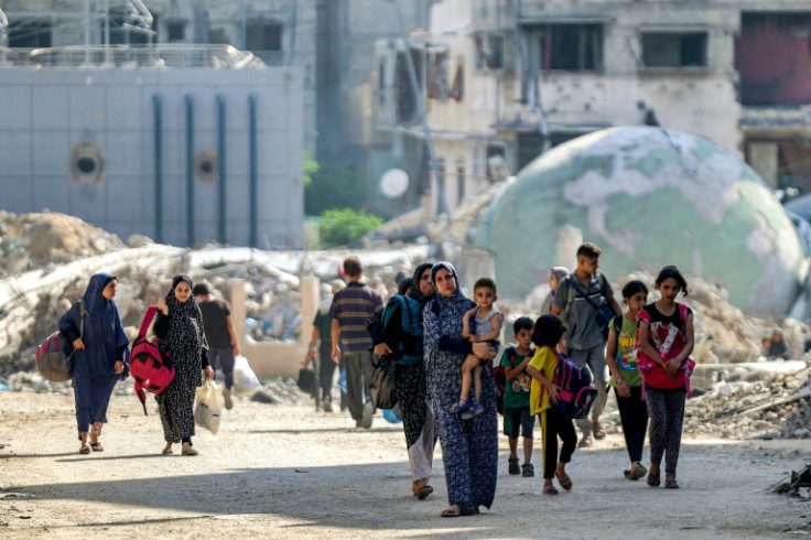 People walk past rubble and damaged buildings in Gaza City's eastern Tuffah district on July 8, 2024