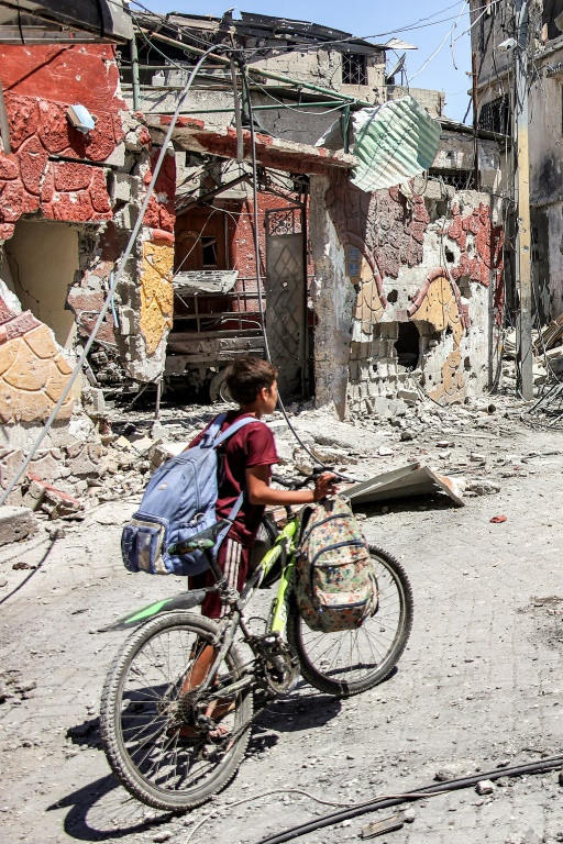 A boy pushing a bicycle in Gaza City's Tuffah district on July 8, 2024 amid the ongoing conflict in the Palestinian territory between Israel and Hamas