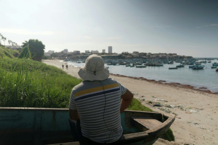 A fisherman sits in a boat at the beach in the Santa Rosa fishing port