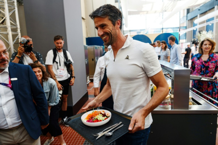Paris 2024 supreme Tony Estanguet tries a salad at the village restaurant in June
