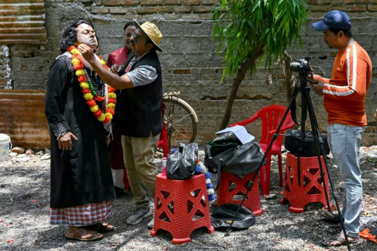 An actor gets his makeup done before a scene at a movie shoot in Malegaon