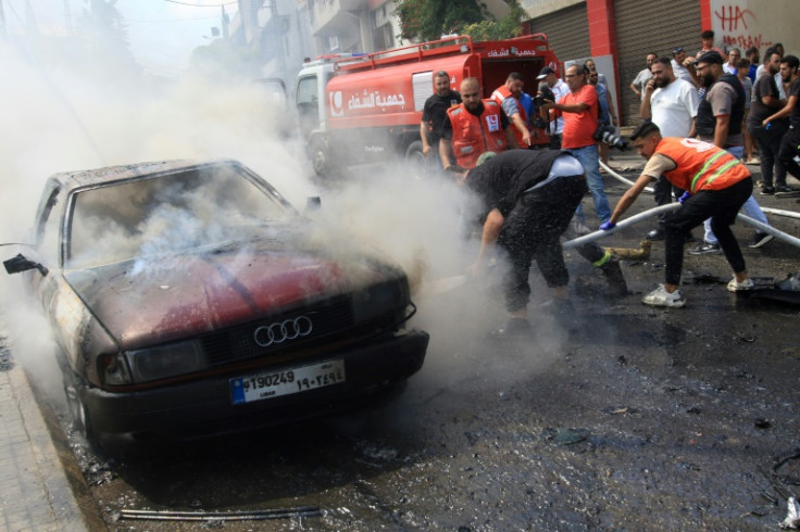Lebanese firefighters battle a blaze in a car after an Israeli strike killed senior Fatah militant Khalil Maqdah