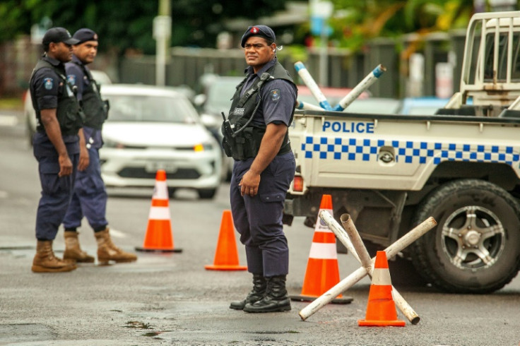 Police officers stand guard at a security check post on the streets of Suva, Fiji