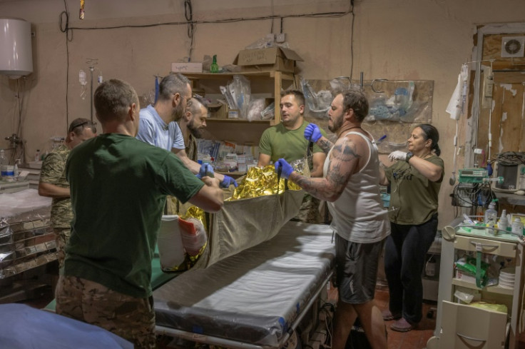 A Ukrainian wounded serviceman brought from frontline positions is treated by Ukrainian military medics