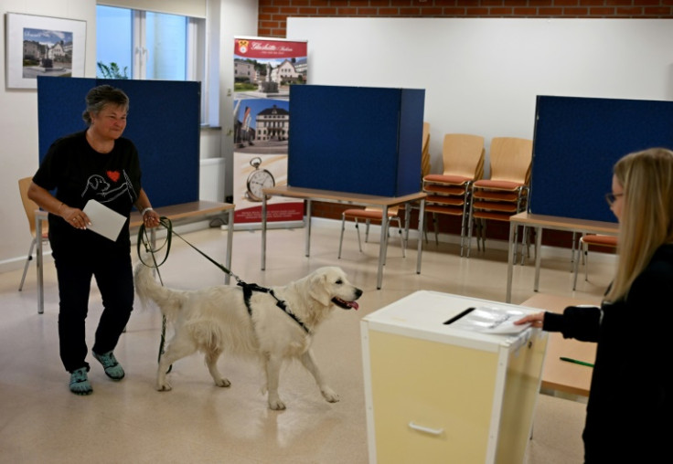 A voter with her dog arrives to cast her ballot at a polling station set up in a school near Dresden