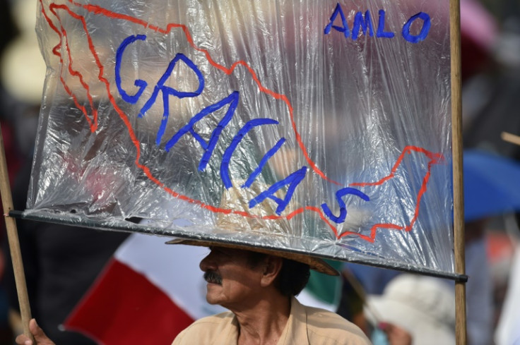 A supporter of Mexico's outgoing president holds a hand-painted sign with the Spanish word for 'Thank you' as crowds filled Mexico City's Zocalo Square on September 1, 2024