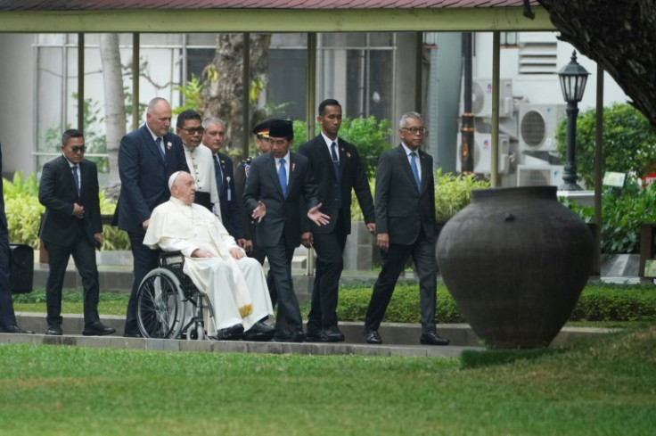 Pope Francis in his wheelchair moves to the State Palace with Indonesia's President Joko Widodo (3rd R) in Jakarta