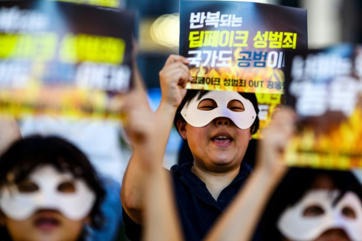 Activists wearing eye masks, hold posters reading ‘Repeated deepfake sex crimes, the state is an accomplice too’ during a protest against deepfake porn in Seoul on August 30, 2024