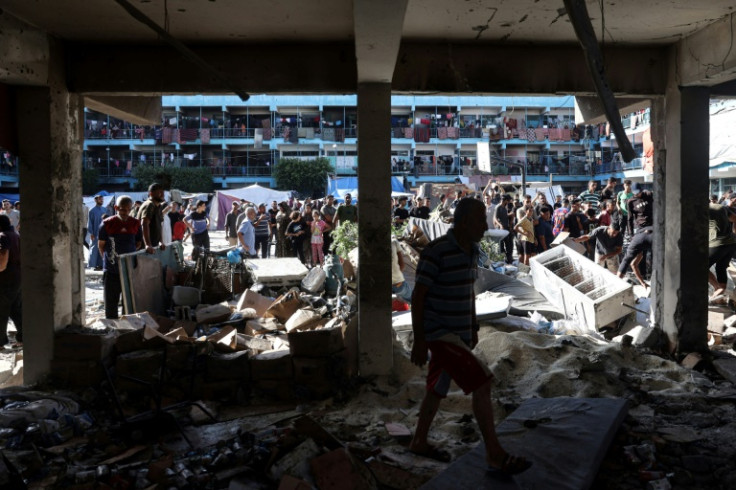 Palestinians survey the Al-Jawni school in central Gaza after an Israeli air strike