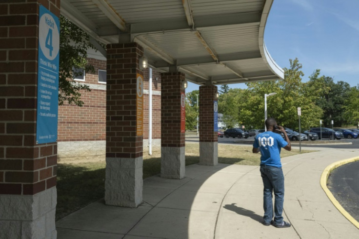 A Haitian father trying to pick up his child speaks on the phone in front of Fulton Elementary School, in Springfield, Ohio, after it was evacuated following bomb threats that were made in the city amid racist rumors about its immigrant population