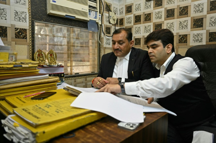 Lawyers go through a case file at the court complex in Ghaziabad. More than half a million cases have been pending for more than two decades in India's glacially slow legal process