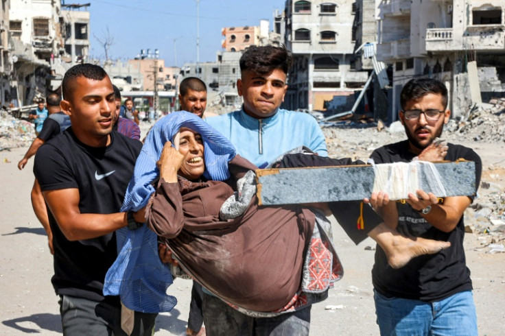 Men carry an injured woman at the Jabalia camp for Palestinian refugees in the northern Gaza which has been under siege since last weekend