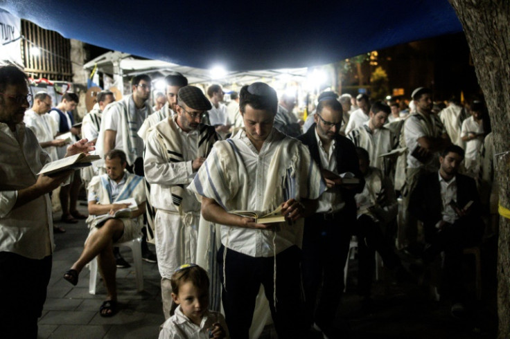 Relatives and friends of Israelis taken hostage by Hamas militants in Gaza block a road to pray for their release at the start of the Jewish holiday of Yom Kippur in Jerusalem