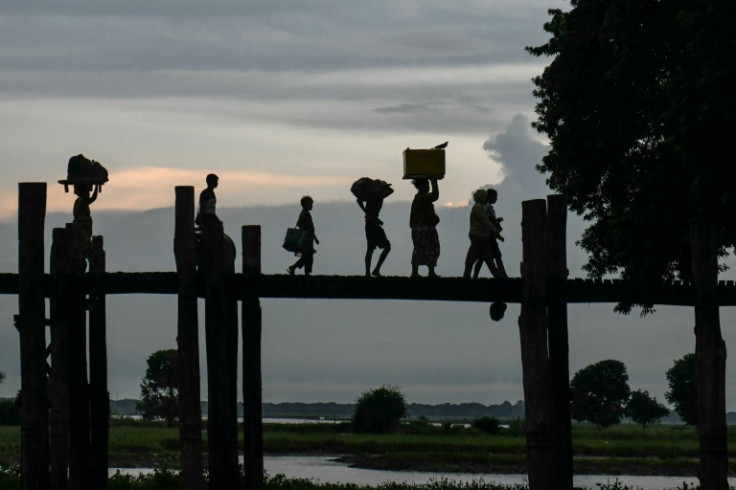 People walk on U Bein bridge at Taungthaman Lake in Mandalay