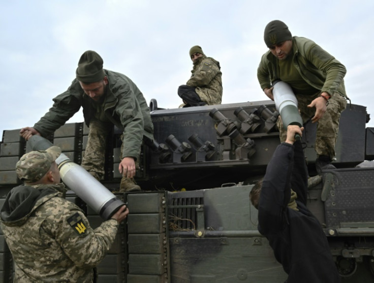Servicemen from Ukraine's 33rd separate mechanized brigade load projectiles onto a Leopard 2A4 tank during training