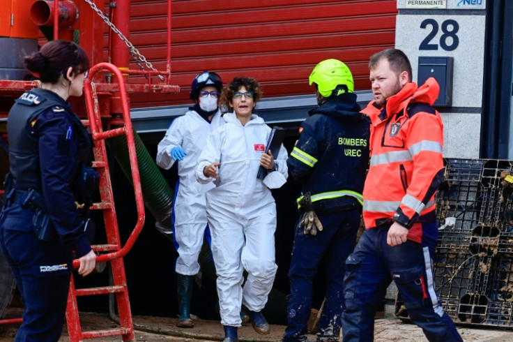 Forensic teams, firefighters and police enter a parking garage as the search for victims continues in Alfafar