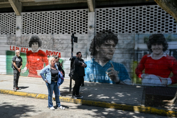 People stand near a mural in honor of the late Argentine soccer hero Diego Maradona in Buenos Aires