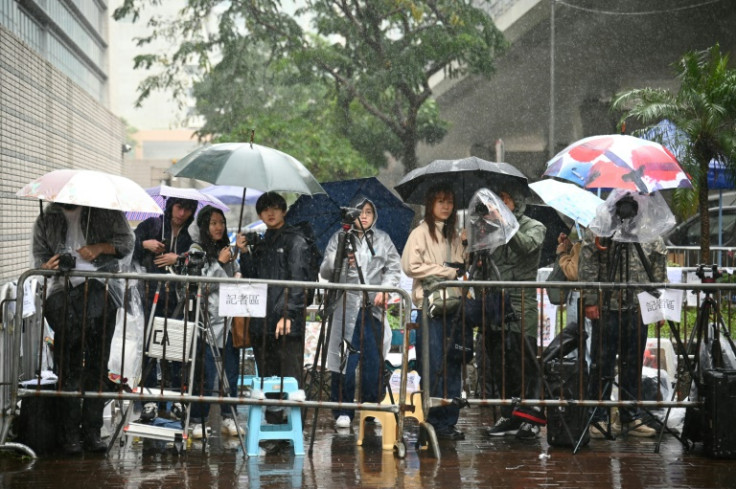 Members of the media wait in heavy rain outside the West Kowloon Magistrates' court in Hong Kong on Wednesday