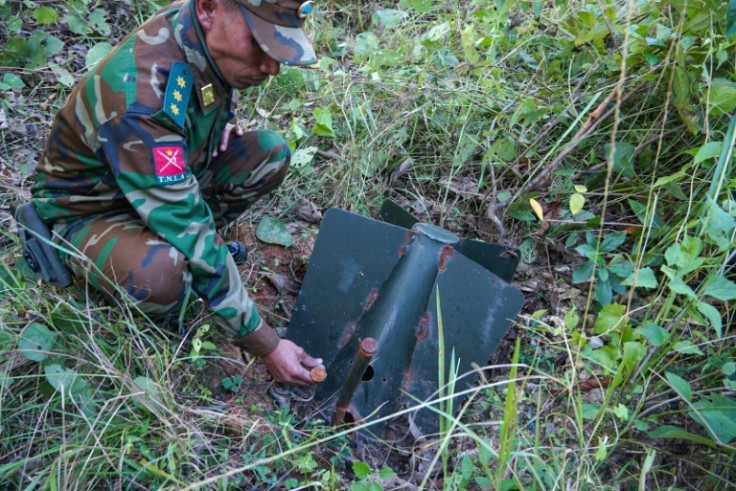 A Ta'ang National Liberation Army (TNLA) member looks at a Myanmar military unexploded ordnance in Mantong town, northern Shan State