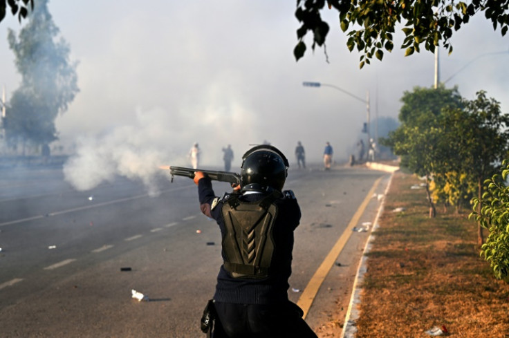A policeman fires rubber bullets to disperse supporters of the Pakistan Tehreek-e-Insaf party in Islamabad