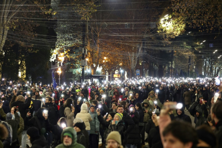 Anti-government demonstrators light up their mobile phones as they protest the Georgian government's postponement of European Union accession talks
