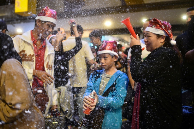 People play with artificial snow made of foam on Christmas Eve in Kuala Lumpur, Malaysia
