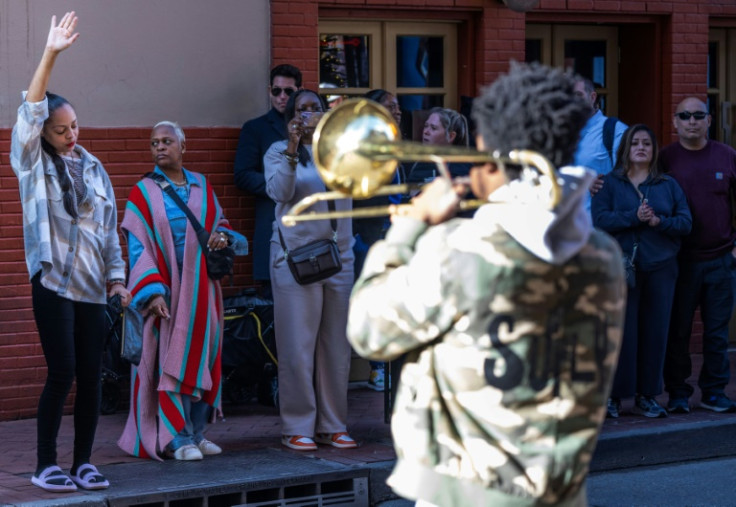 Samantha Petry (L) dances after placing flowers at a memorial on Bourbon Street