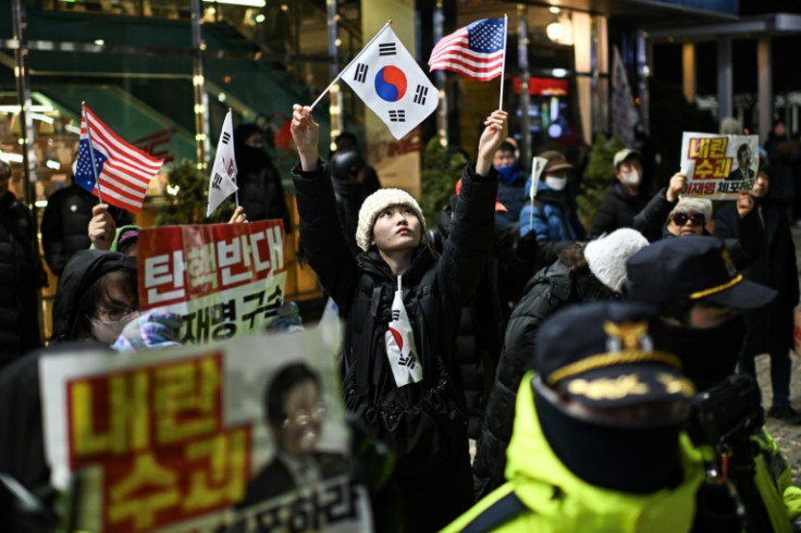A supporter of South Korea's impeached president Yoon Suk Yeol waves flags of South Korea and the United States