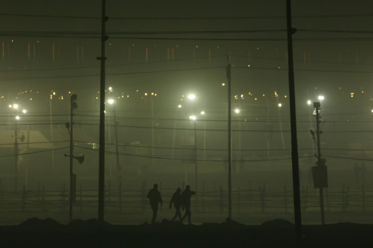 People walk near the banks of river Ganges ahead of the Maha Kumbh Mela festival on January 10, 2025
