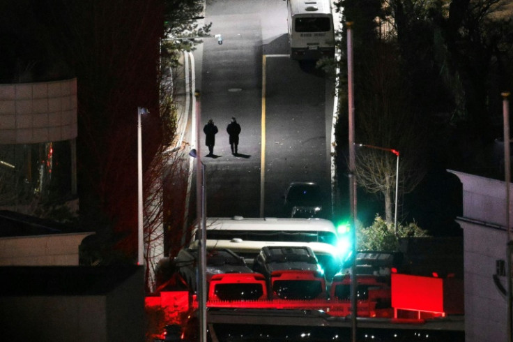 People walk down a road within the entrance gates of the compound of the presidential residence of impeached South Korea president Yoon Suk Yeol