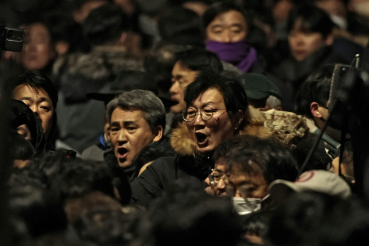 People gather inside the barricade blocking the road leading to the residence of impeached South Korean President Yoon Suk Yeol