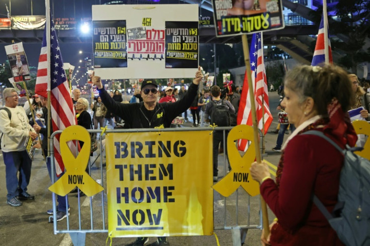 A demonstrator raises a placard during a protest calling for action to secure the release of Israelis held hostage in Gaza since the October 2023, in front of the Israeli defence ministry in Tel Aviv on January 15, 2025