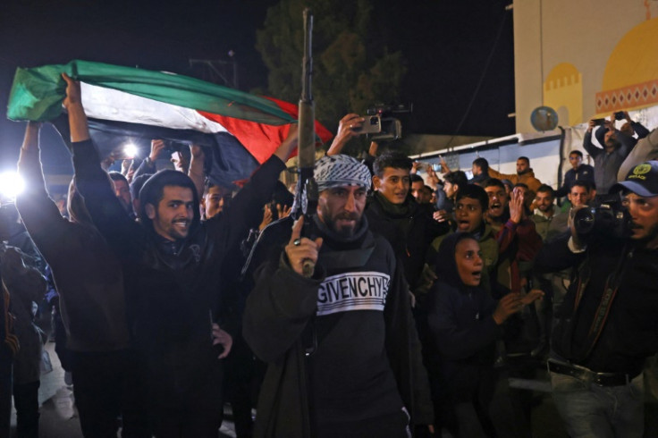 People celebrate while watching a television along a street in Khan Yunis in southern Gaza on January 15, 2025 as news spread that a ceasefire had been reached