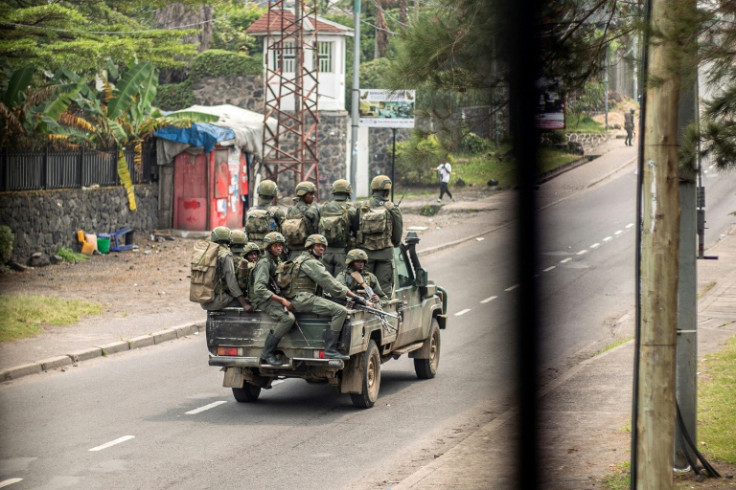 Armed men travel in a pickup truck, devoid of any insignia or markings, as they drive through a street in Goma on January 28, 2025
