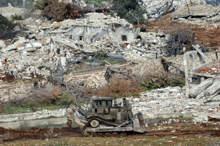 An Israeli military excavator drives past destroyed houses in the Lebanese village of Dhayra near the border with northern Israel, on February 17, 2025