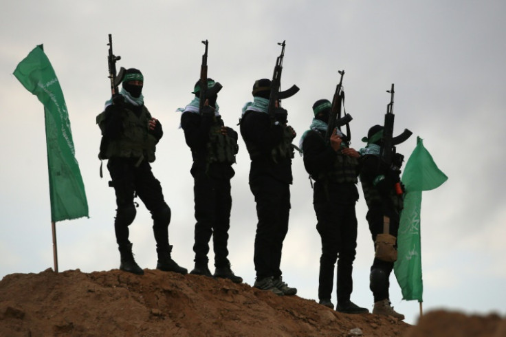 Palestinian Hamas militants gather at the site of the handover of four Israeli hostages' bodies