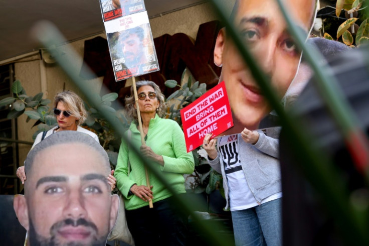 Israelis raise cutout portraits of hostages during a protest in Tel Aviv calling for the implementation of the second phase of the Gaza ceasefire