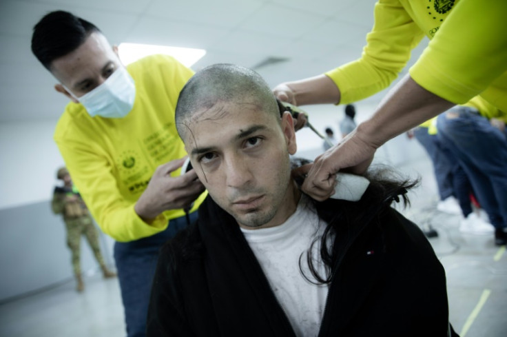 This handout picture from El Salvador's presidency press office shows an alleged member of the Venezuelan criminal group Tren de Aragua being shaved upon arrival at the Terrorism Confinement Center in El Salvador after expulsion from the US