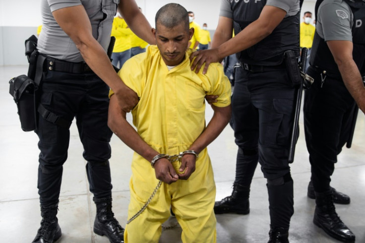 This handout from El Salvador's presidency press office shows an alleged member of the Venezuelan criminal organization Tren de Aragua upon his arrival at Salvador's Terrorism Confinement Center