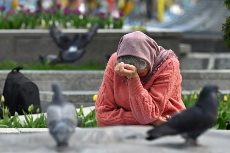 An elderly woman reacts in front of makeshift memorial for the fallen Ukrainian and foreign fighters, at the Independence Square in Kyiv on April 19, 2025, amid the Russian invasion of Ukraine