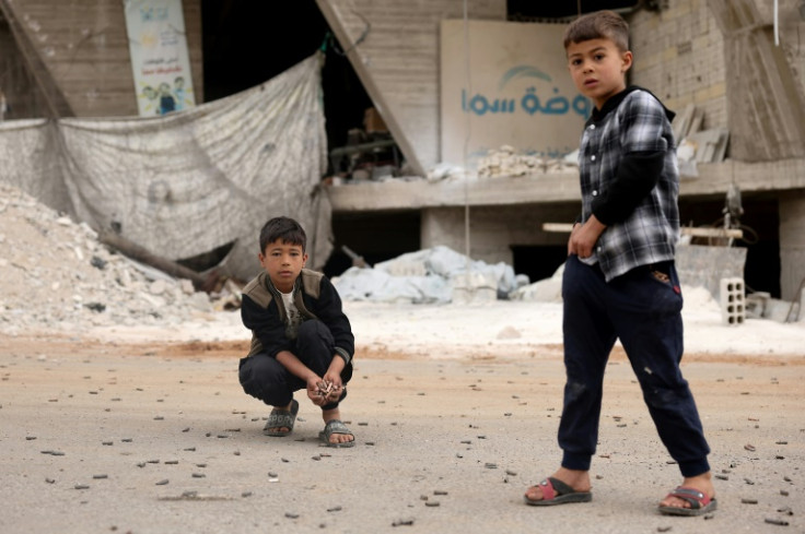 Boys collect bullet casings after the fighting in Sahnaya near Damascus