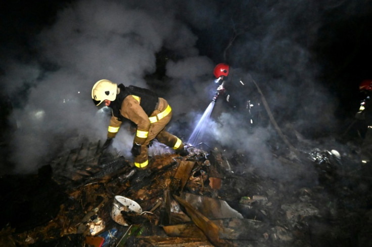 Ukrainian rescuers extinguish a fire at a house after a drone strike on Kharkiv early on May 3