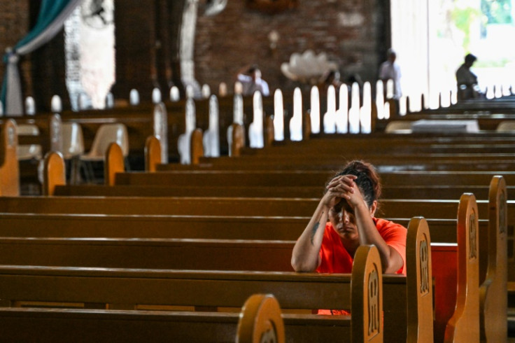 A woman prays inside the cathedral in Imus, a densely populated city where 67-year-old Cardinal Luis Antonio Tagle began his career