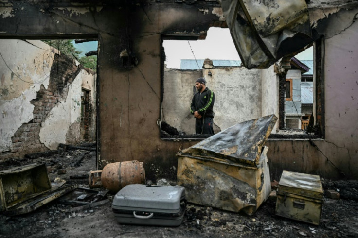 A man stands inside his destroyed home in the border village of Salamabad