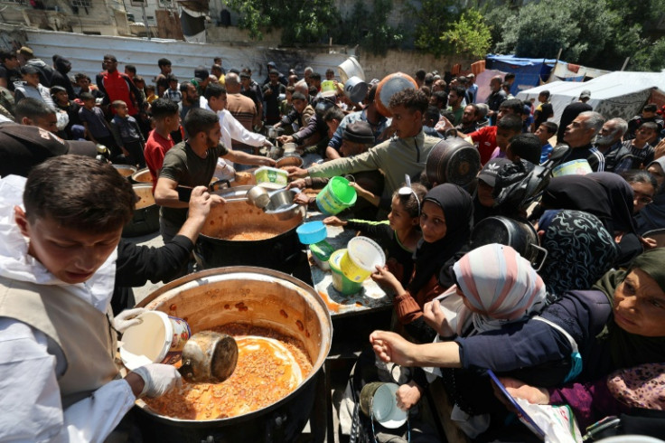 Palestinians queue for a portion of hot food distributed by a charity kitchen at the Nuseirat refugee camp in the central Gaza Strip on May 5, 2025. The humanitarian crisis in the besieged Gaza Strip has worsened significantly since Israel blocked all aid